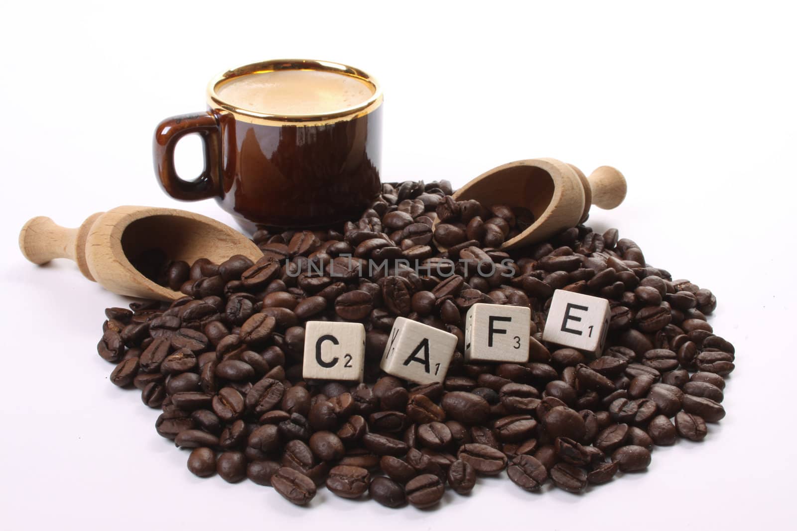 Roasted coffee beans  and a coffee cup and dices forming the word cafe