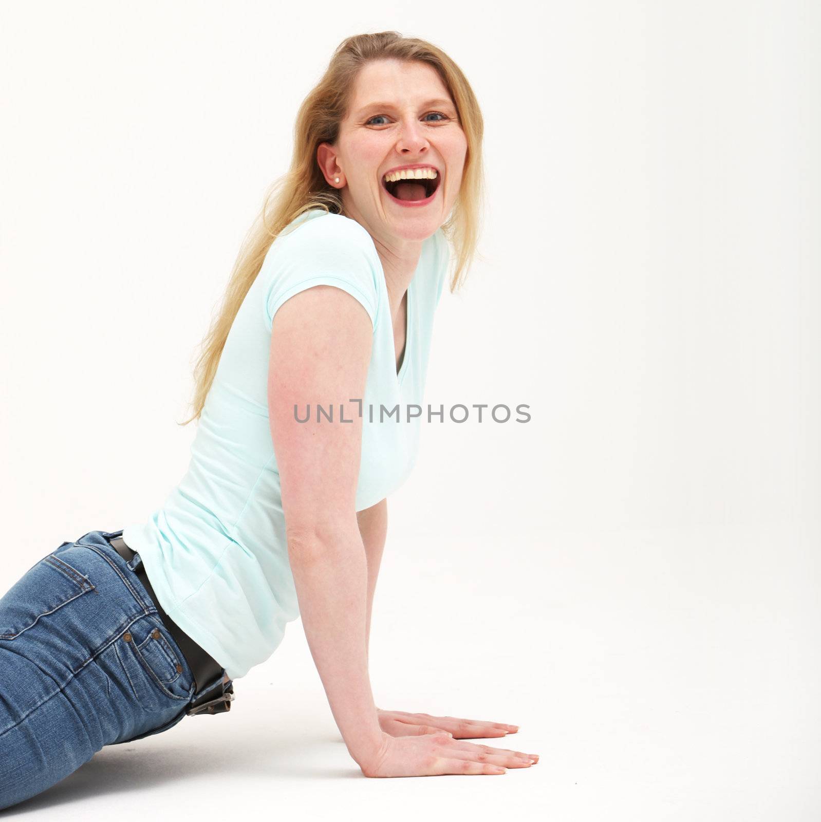 Pretty girl with long blonde hair having fun doing mock push ups with a smile