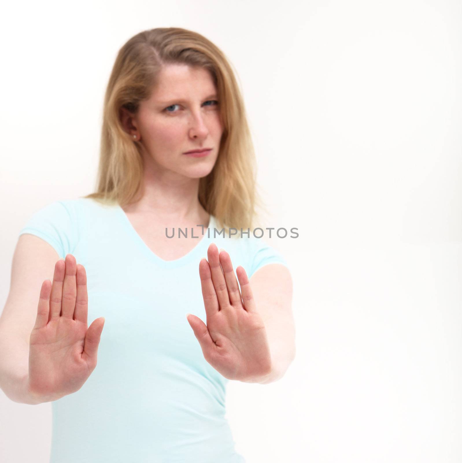 Pretty girl with a serious look holding out her hand signaling stop