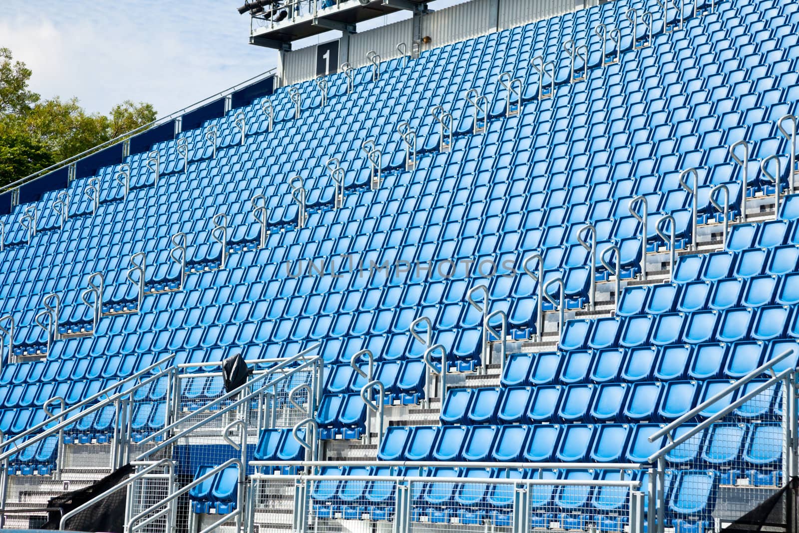 Folded blue plastic chairs on a temporary tribune