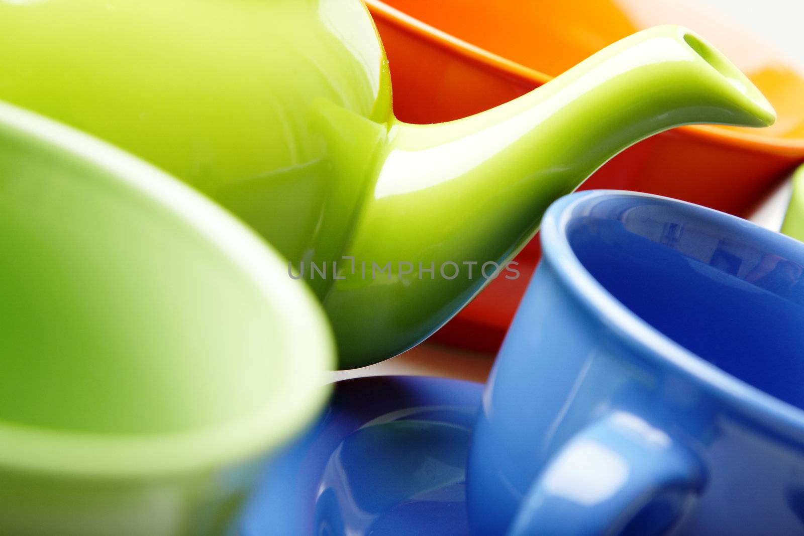 Close-up photo of the fragment of tea service consisting of teapot and cups. Natural color. Shallow depth of field added by the lens for natural view