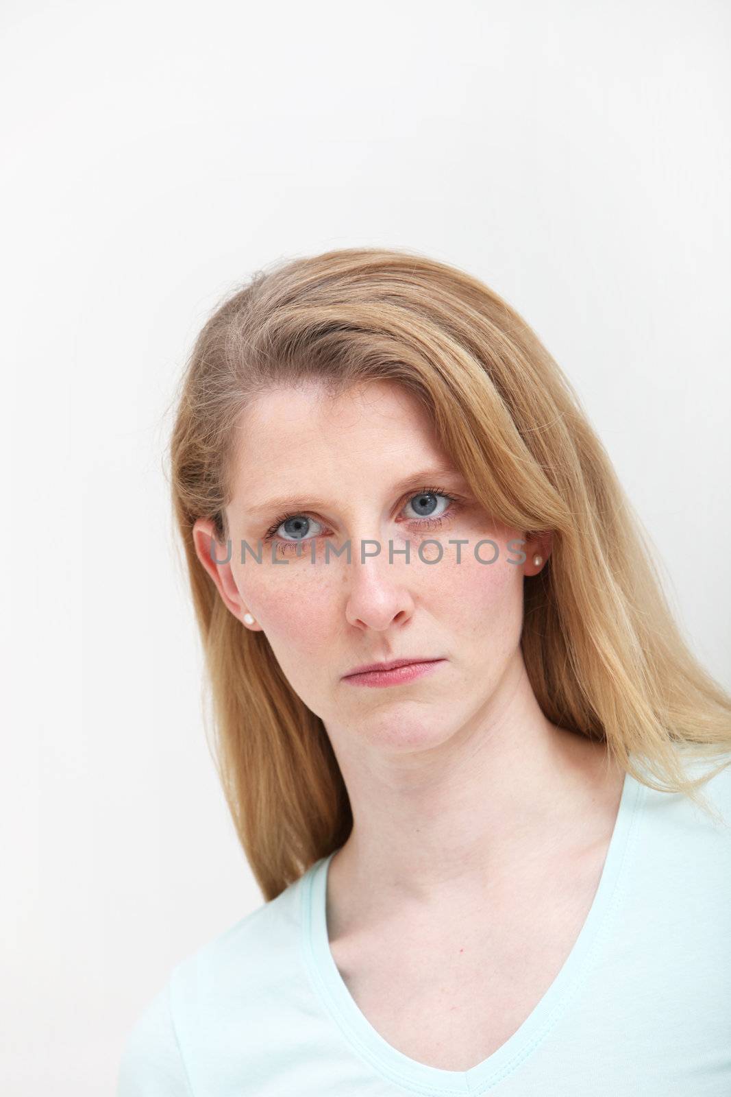 Pretty blonde girl with long hair looking slightly put out about some incident.