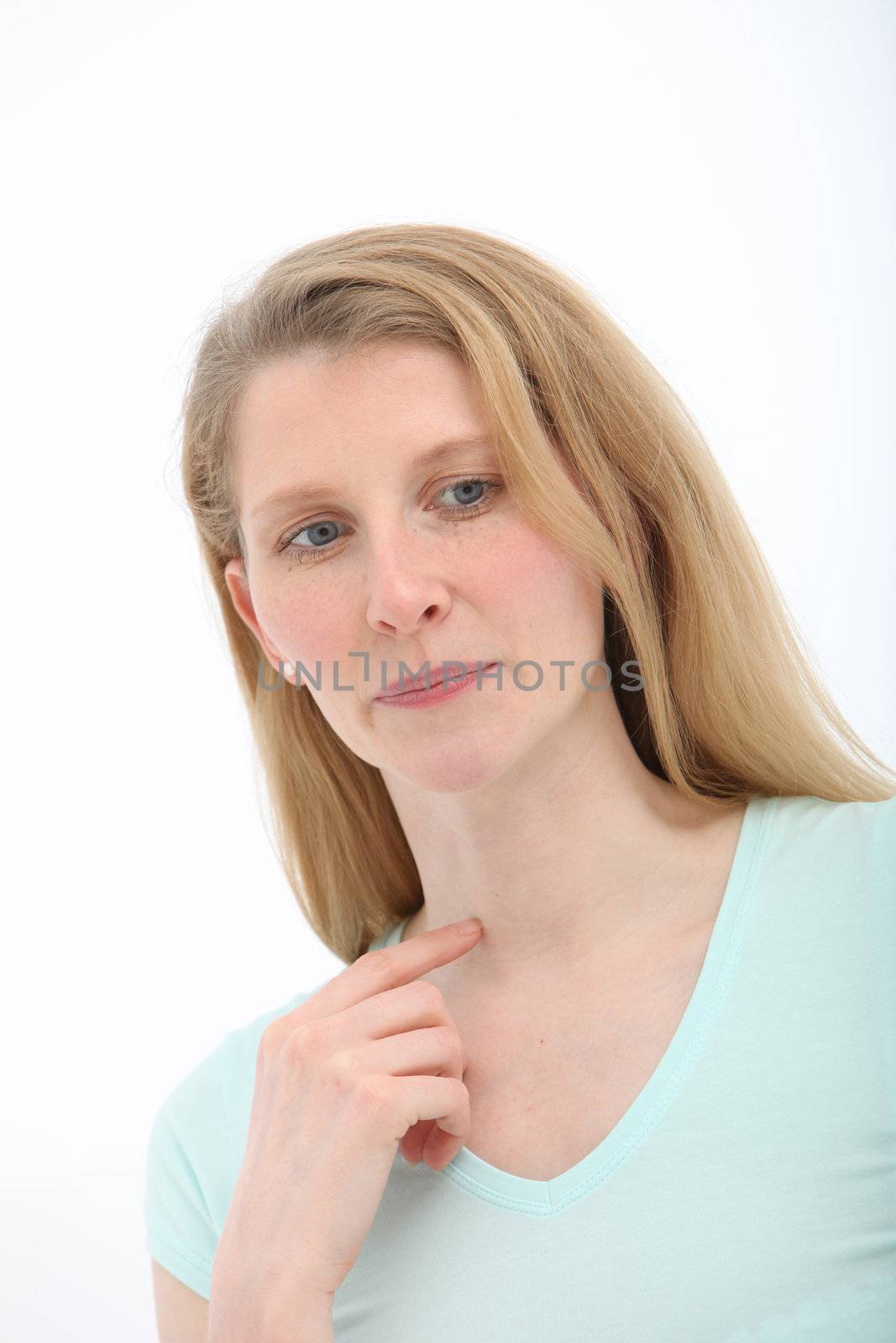 Despondent attractive mature woman with a sad expression and eyes averted on a white studio background