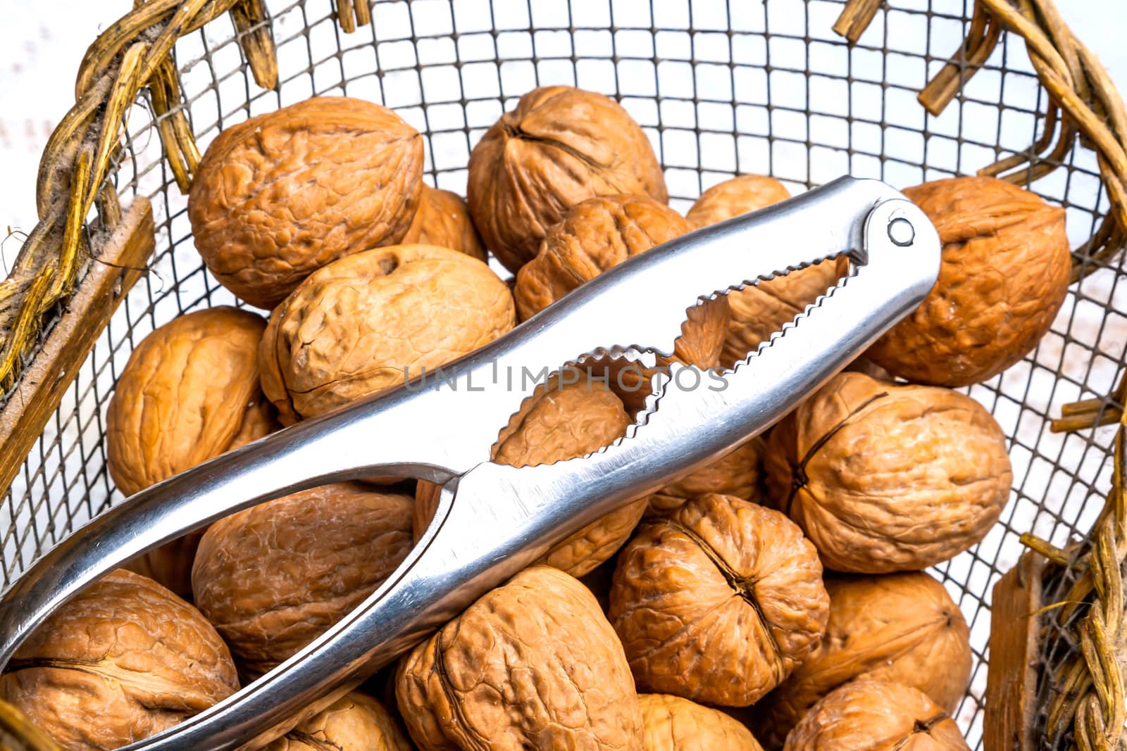 A composition of walnuts, cracked walnuts and a nutcraker