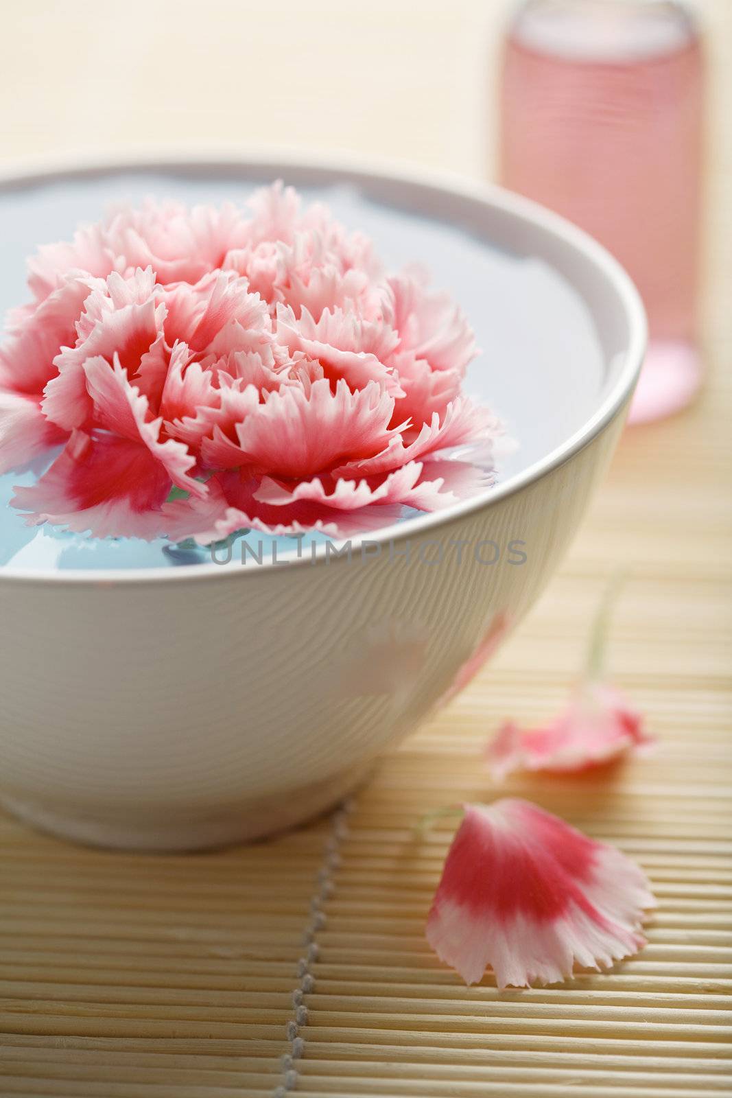 flower in bowl and cosmetic bottle