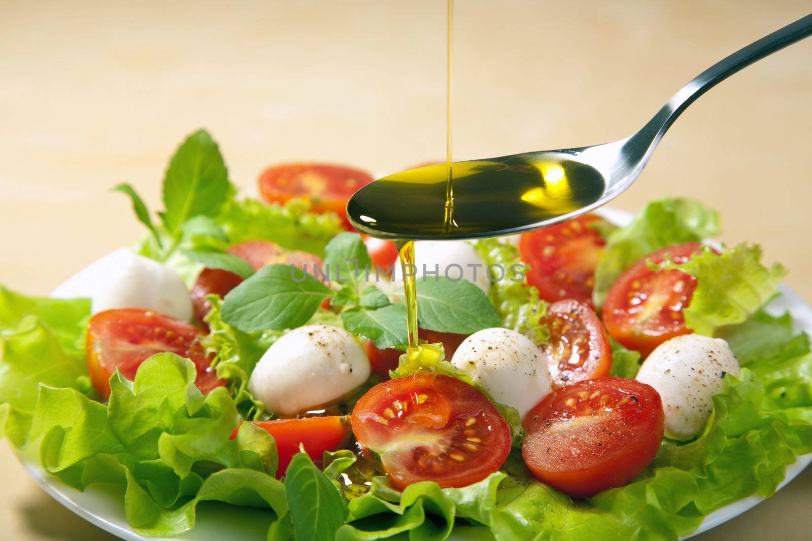 olive oil pouring over salad