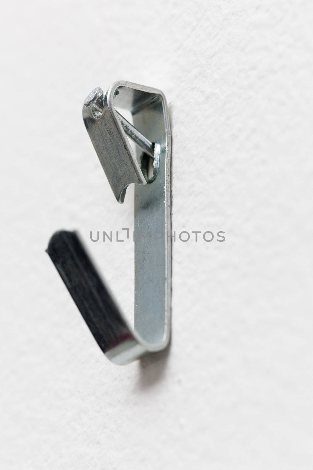 Close up of a metal picture hook nailed to plaster wall ready to mount a picture frame