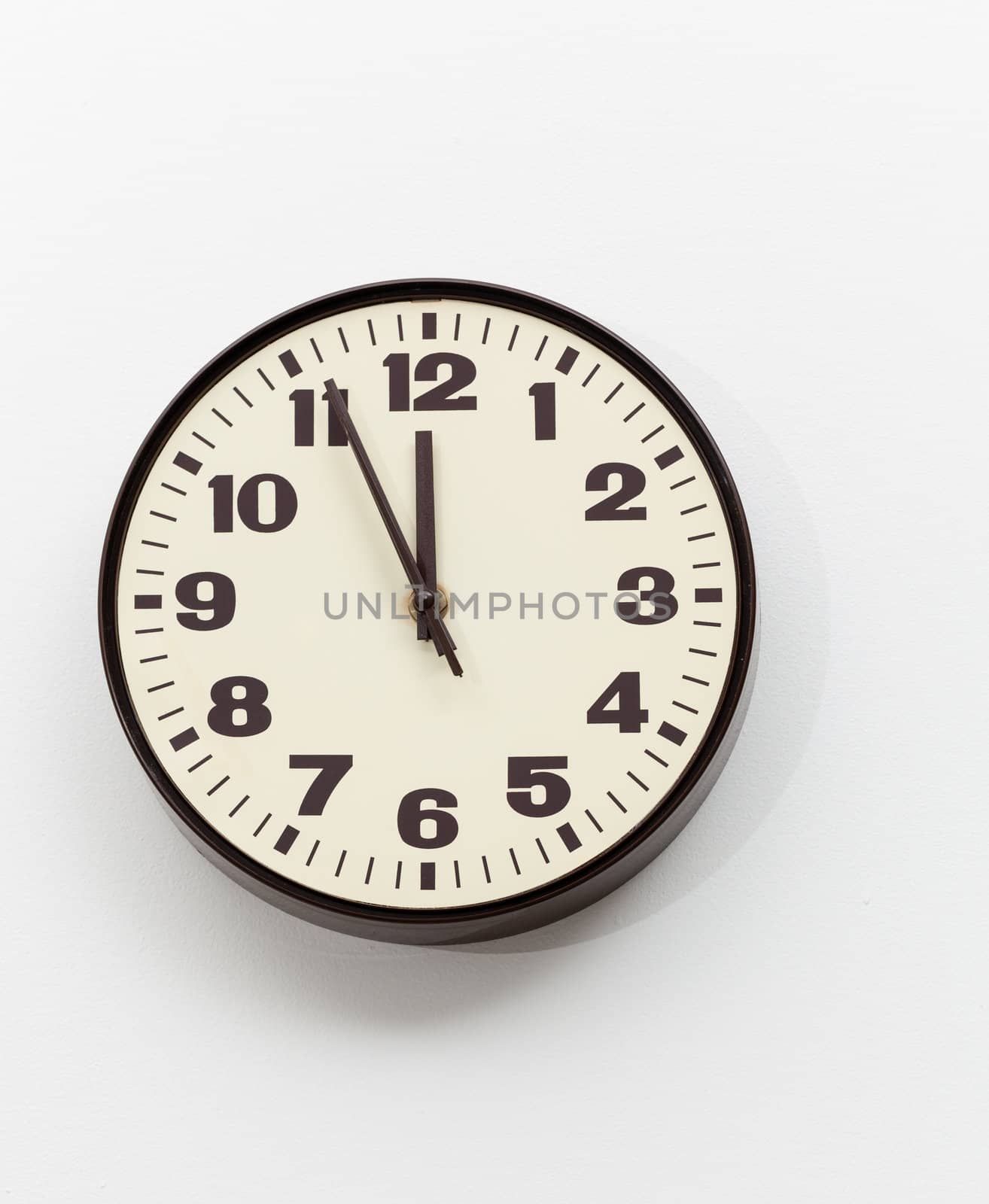 Brown simple plastic wall clock on the wall of office and concept of running out of time