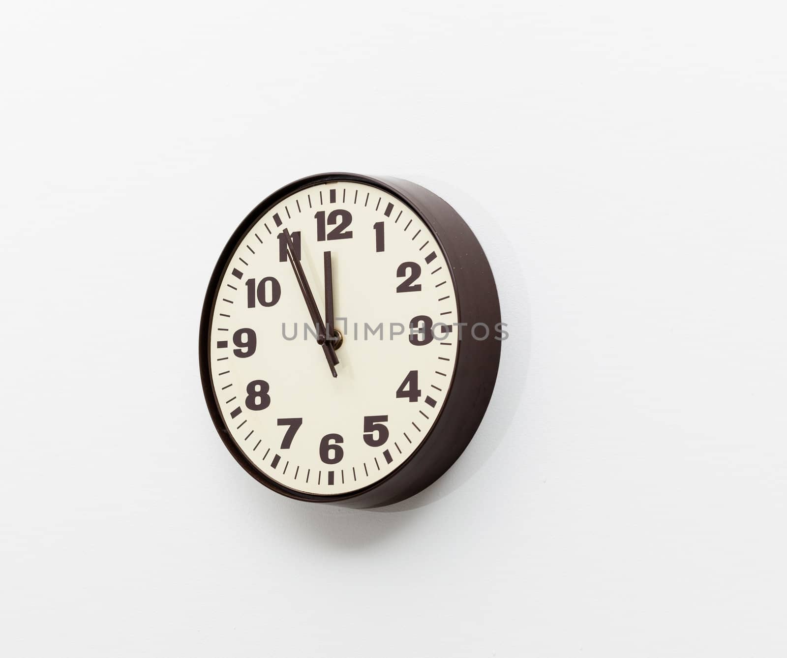 Brown simple plastic wall clock on the wall of office and concept of running out of time