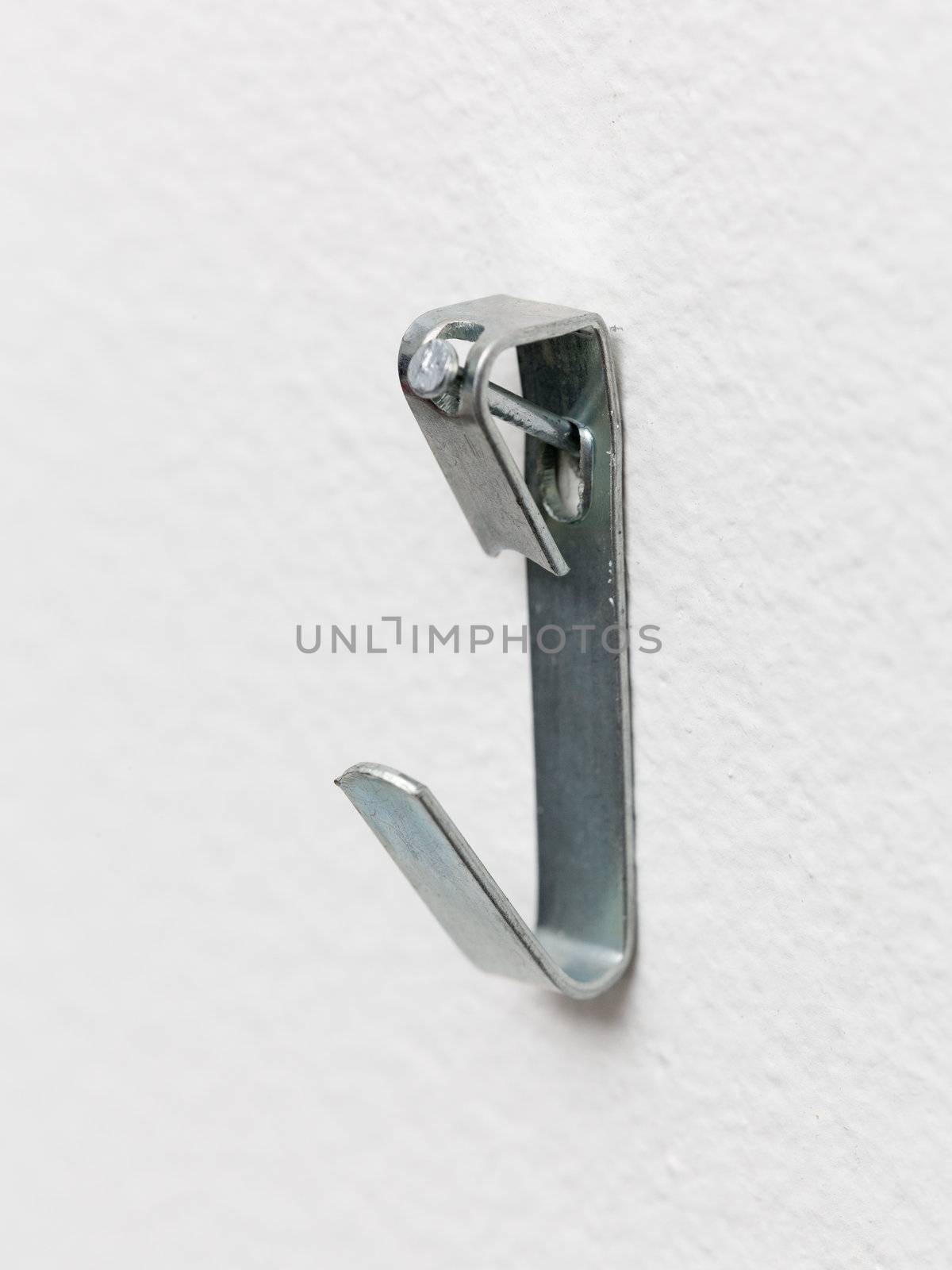 Close up of a metal picture hook nailed to plaster wall ready to mount a picture frame