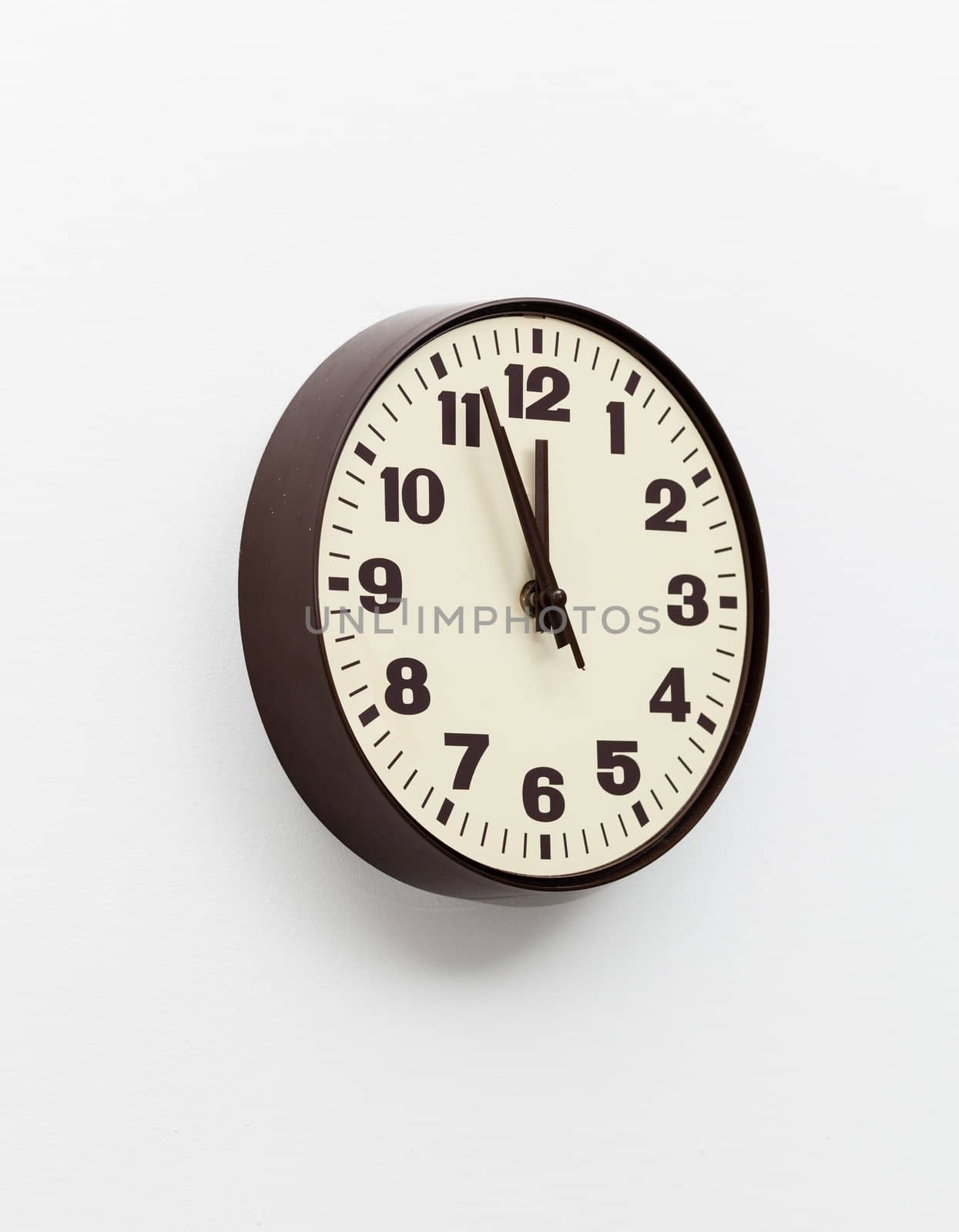 Brown simple plastic wall clock on the wall of office and concept of running out of time