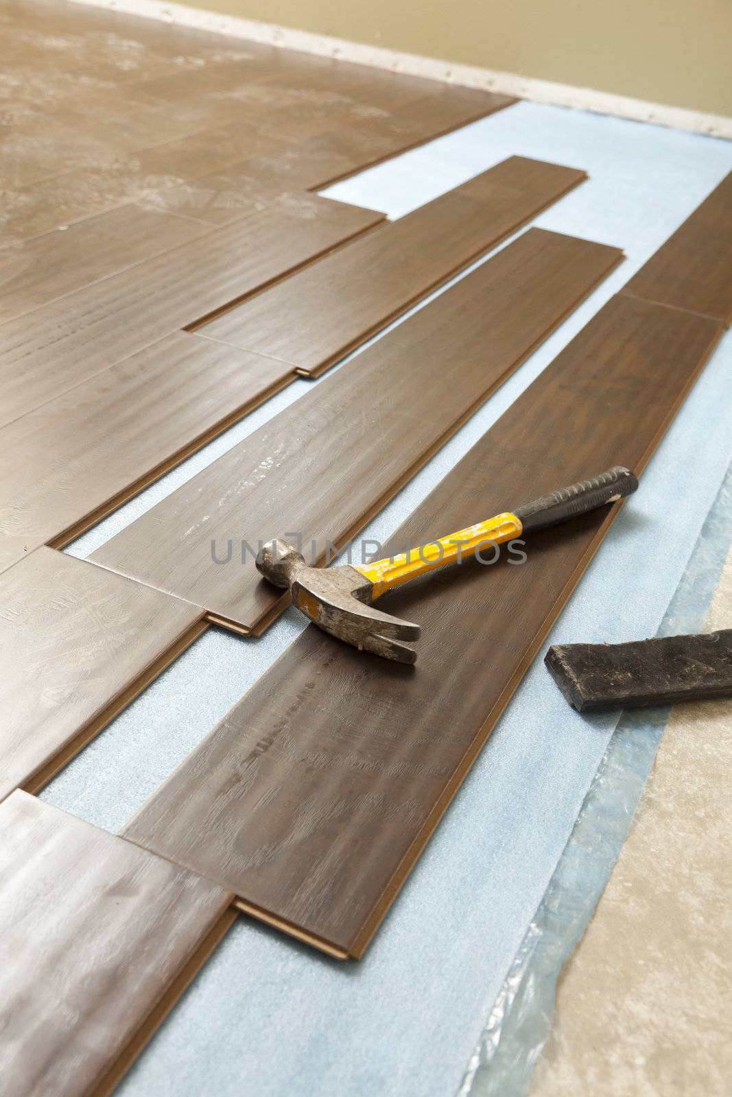 Hammer and Block with New Laminate Flooring Abstract.