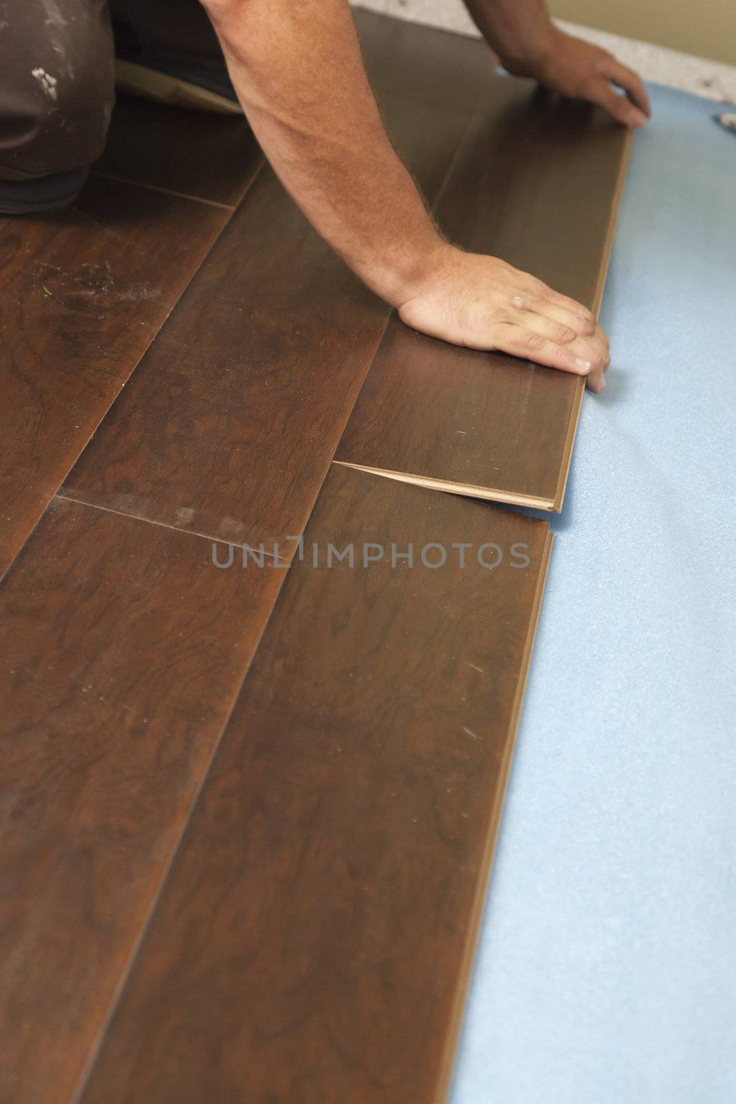 Man Installing New Laminate Wood Flooring Abstract.