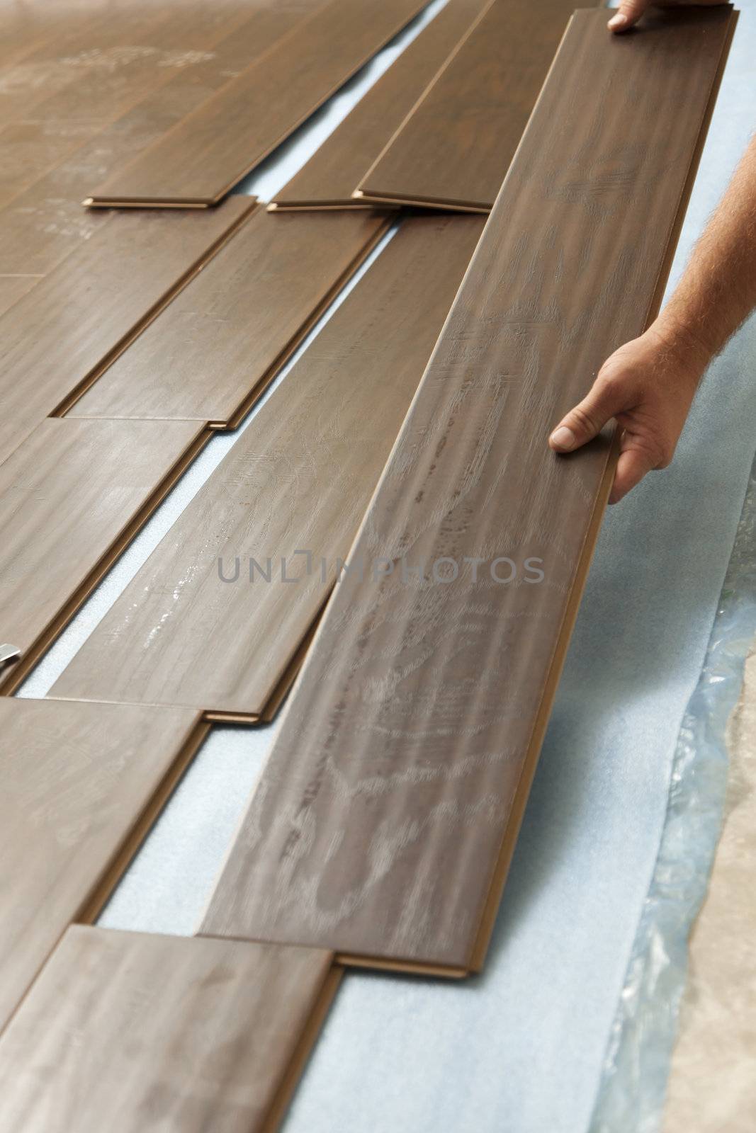 Man Installing New Laminate Wood Flooring Abstract.