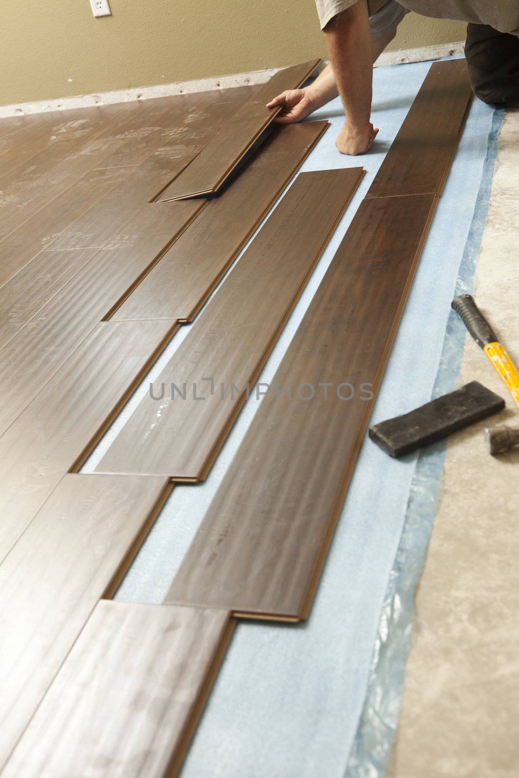 Man Installing New Laminate Wood Flooring Abstract.