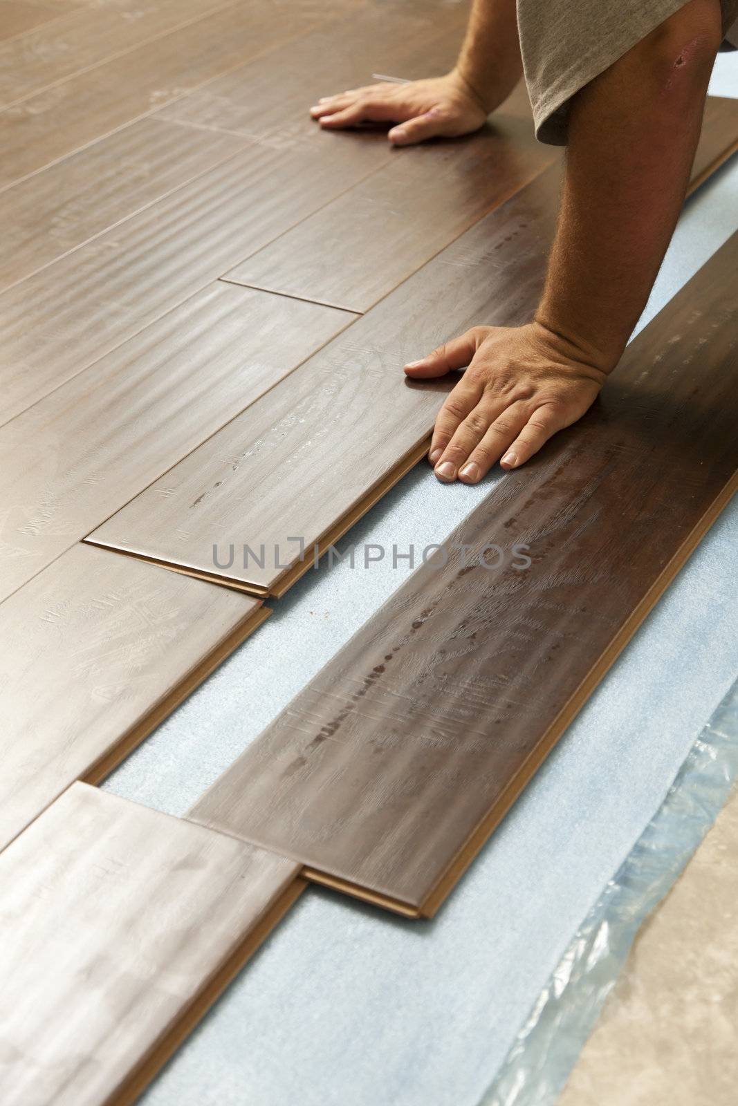 Man Installing New Laminate Wood Flooring Abstract.