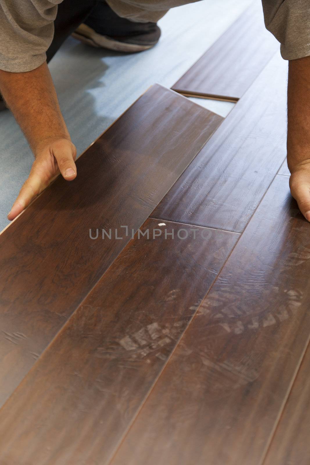 Man Installing New Laminate Wood Flooring by Feverpitched