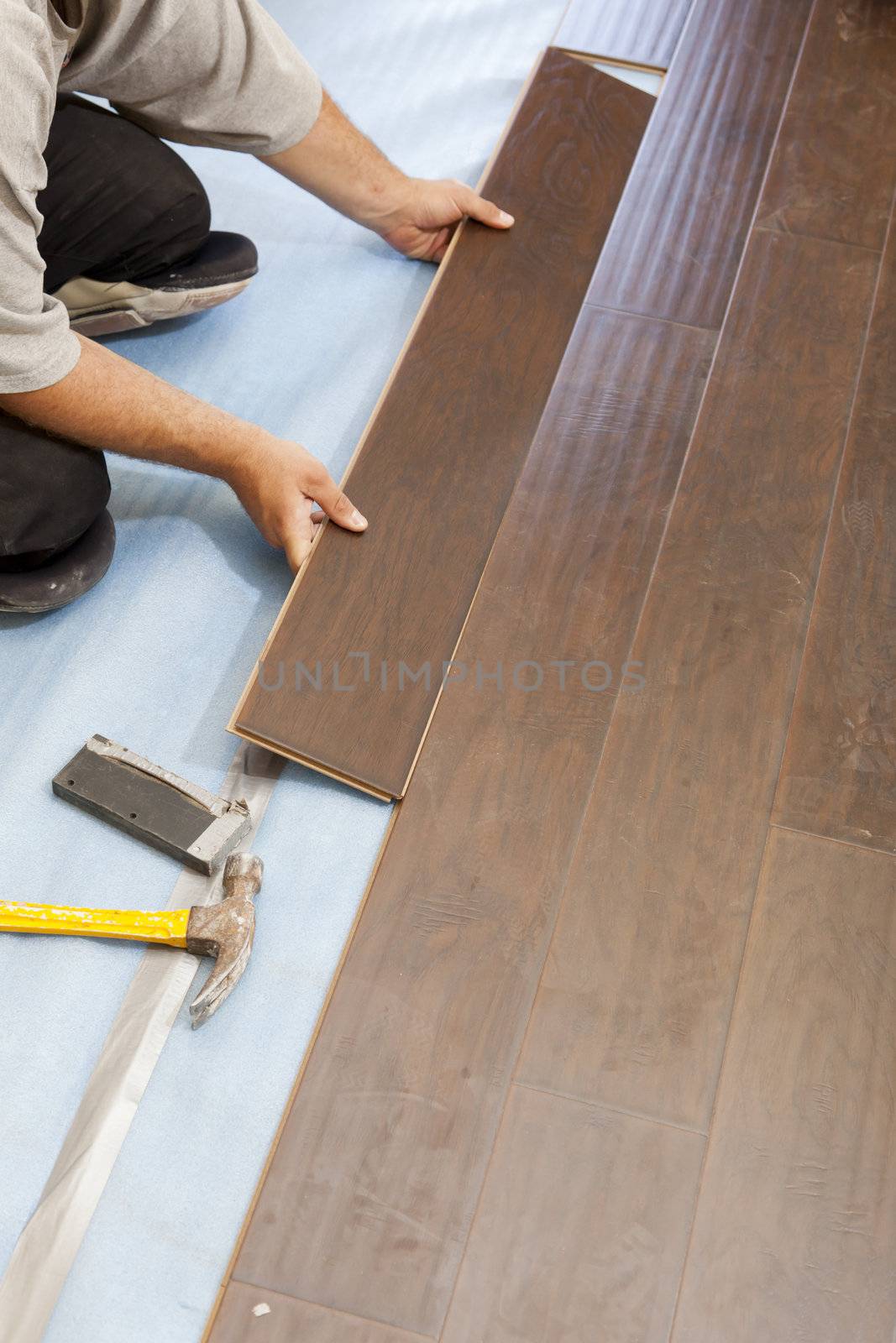 Man Installing New Laminate Wood Flooring Abstract.