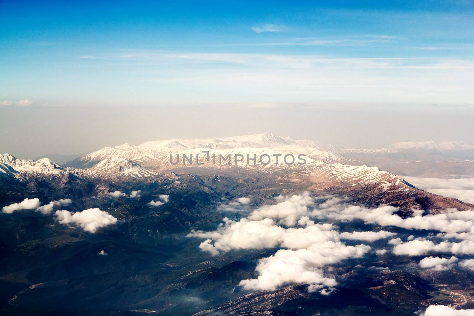 view of the mountains from an airplane above the clouds