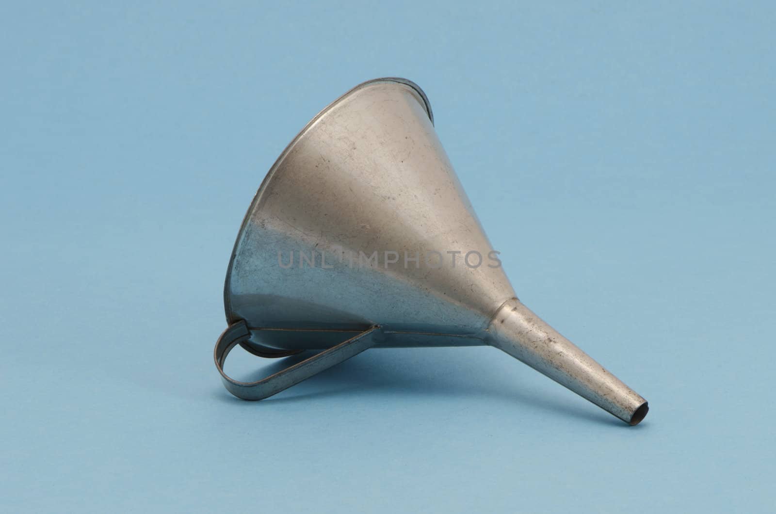 Ancient metal aluminum funnel on blue background by sauletas