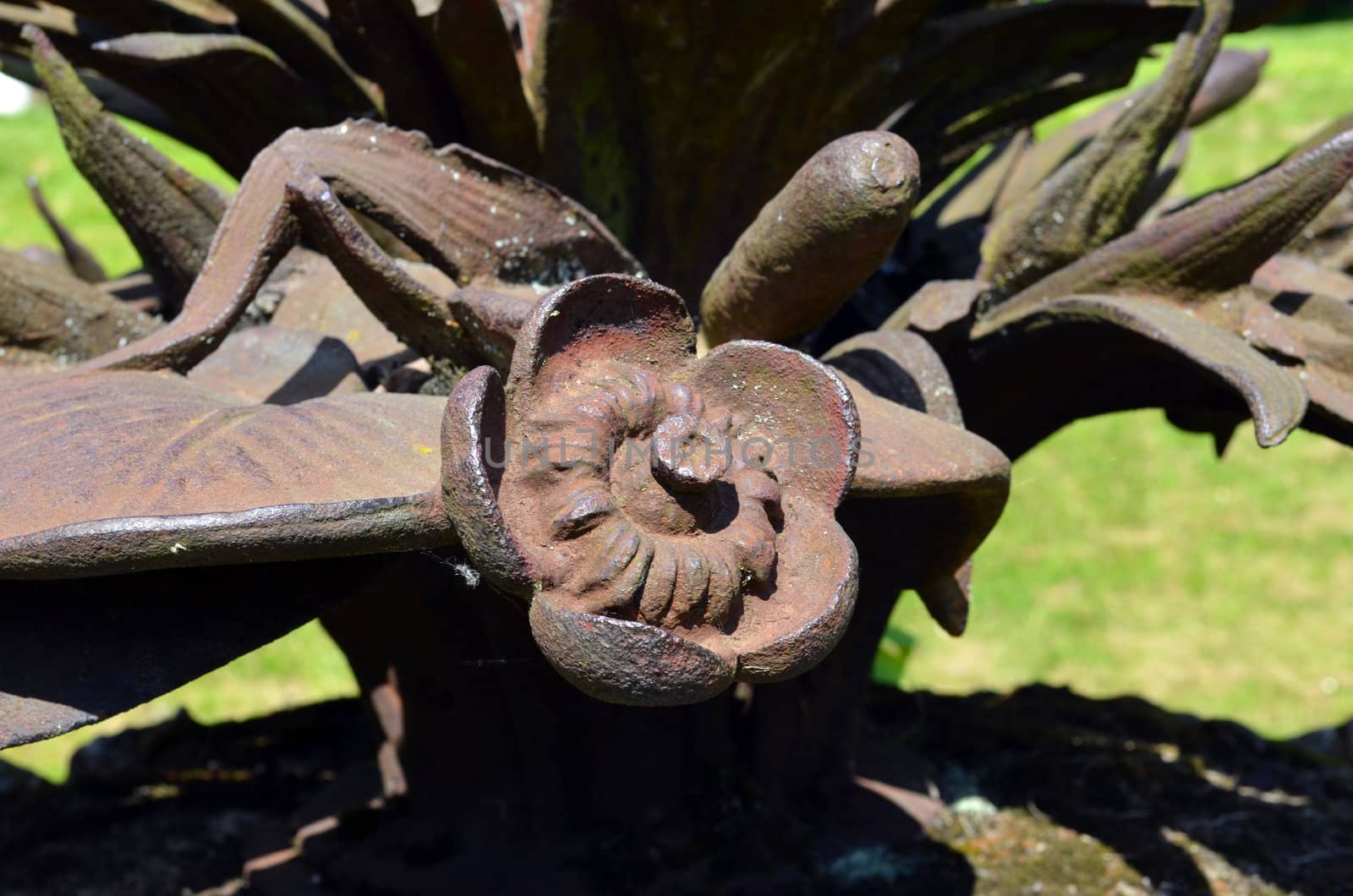 Closeup of unreal rusty steel metal flower imitation. Ancient vintage fountain decoration.