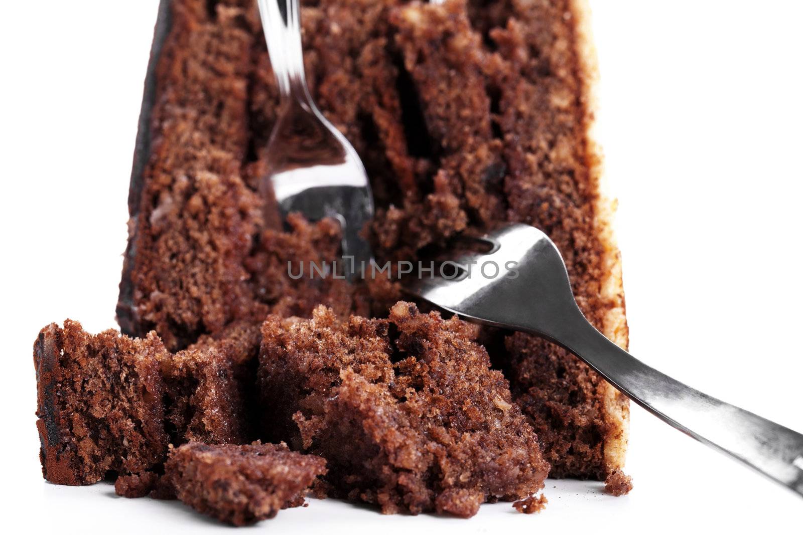 broken chocolate cake with two forks on white background