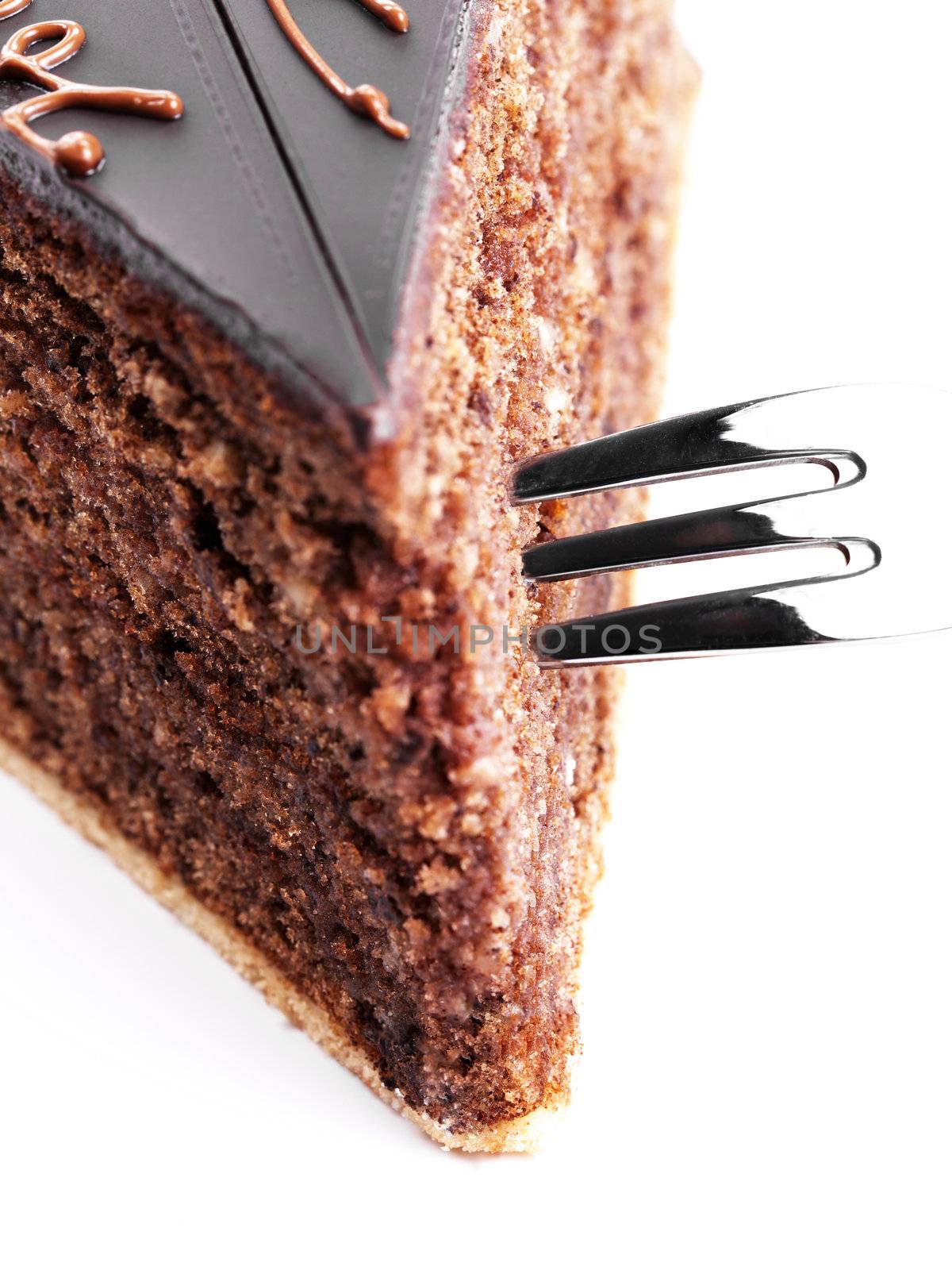 closeup from top of a fork in a chocolate cake on white background