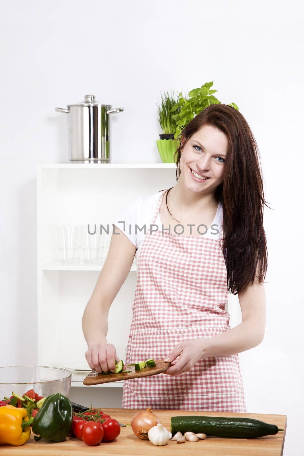 woman adding cucumber to her salad by RobStark