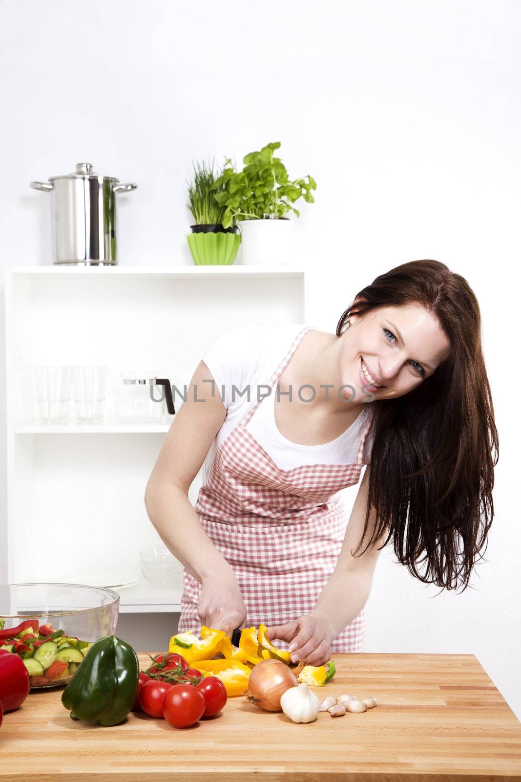 happy woman chopping yellow paprika by RobStark