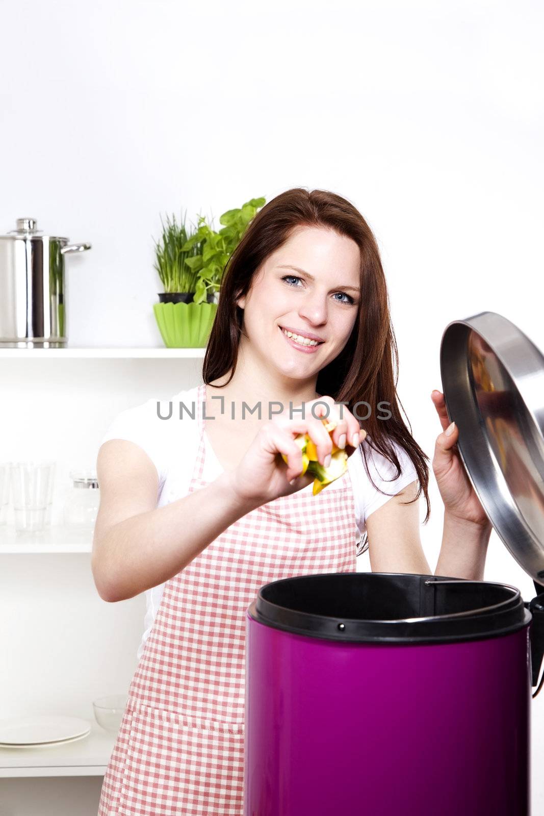 young smiling woman throwing away some organic waste