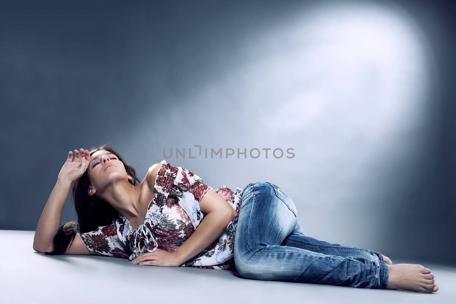 young woman wearing blue jeans lying on the floor by RobStark