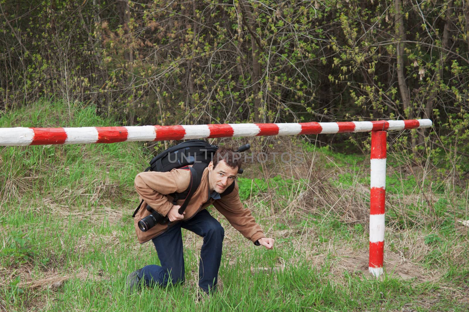 A young man with a backpack passes under the barrier