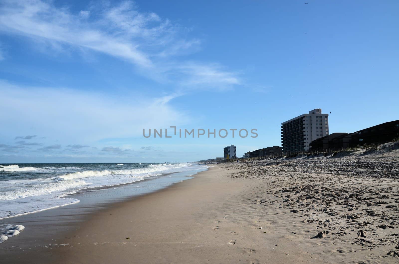 A view of the shore in North Carolina showing condos and surf.