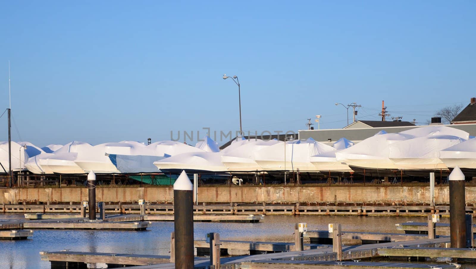 A boat yard with the boats covered in plastic until spring.