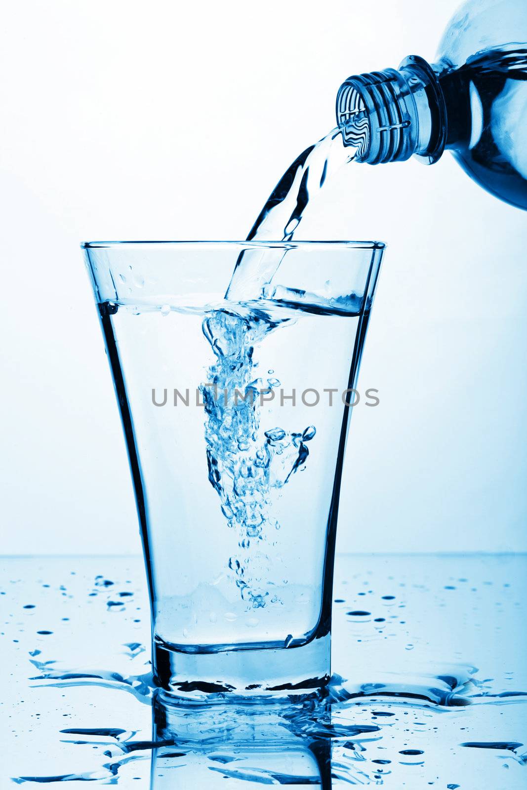 pure water splashing from bottle into glass