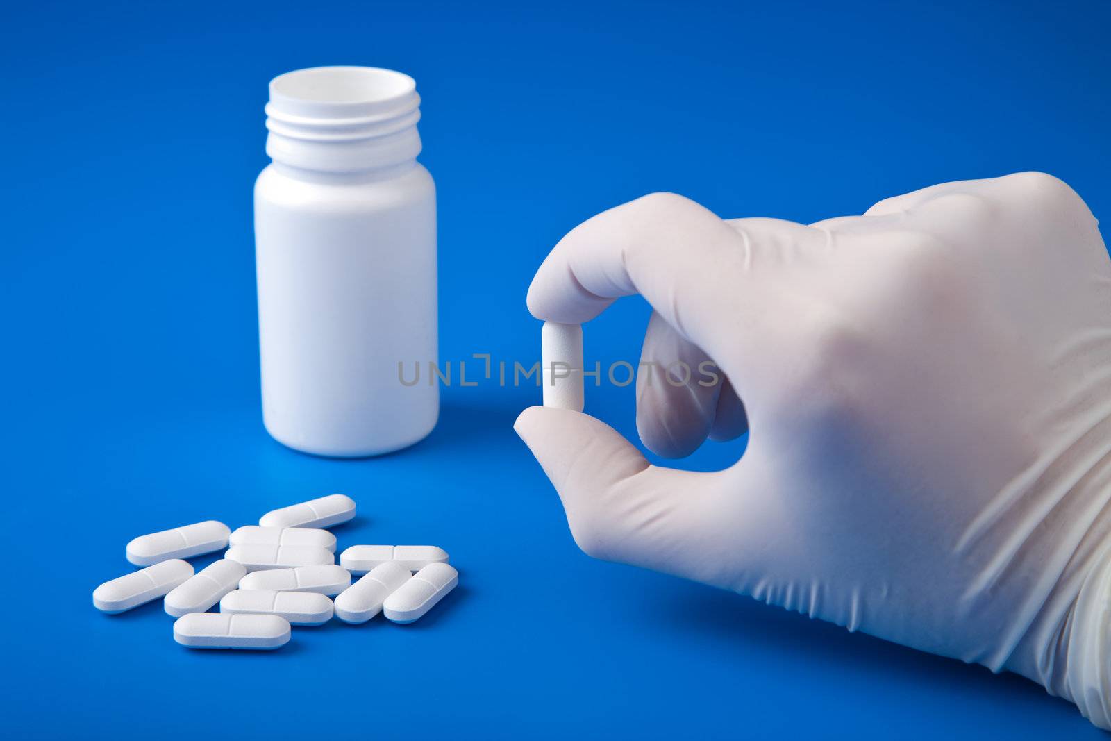 hand holding white pill