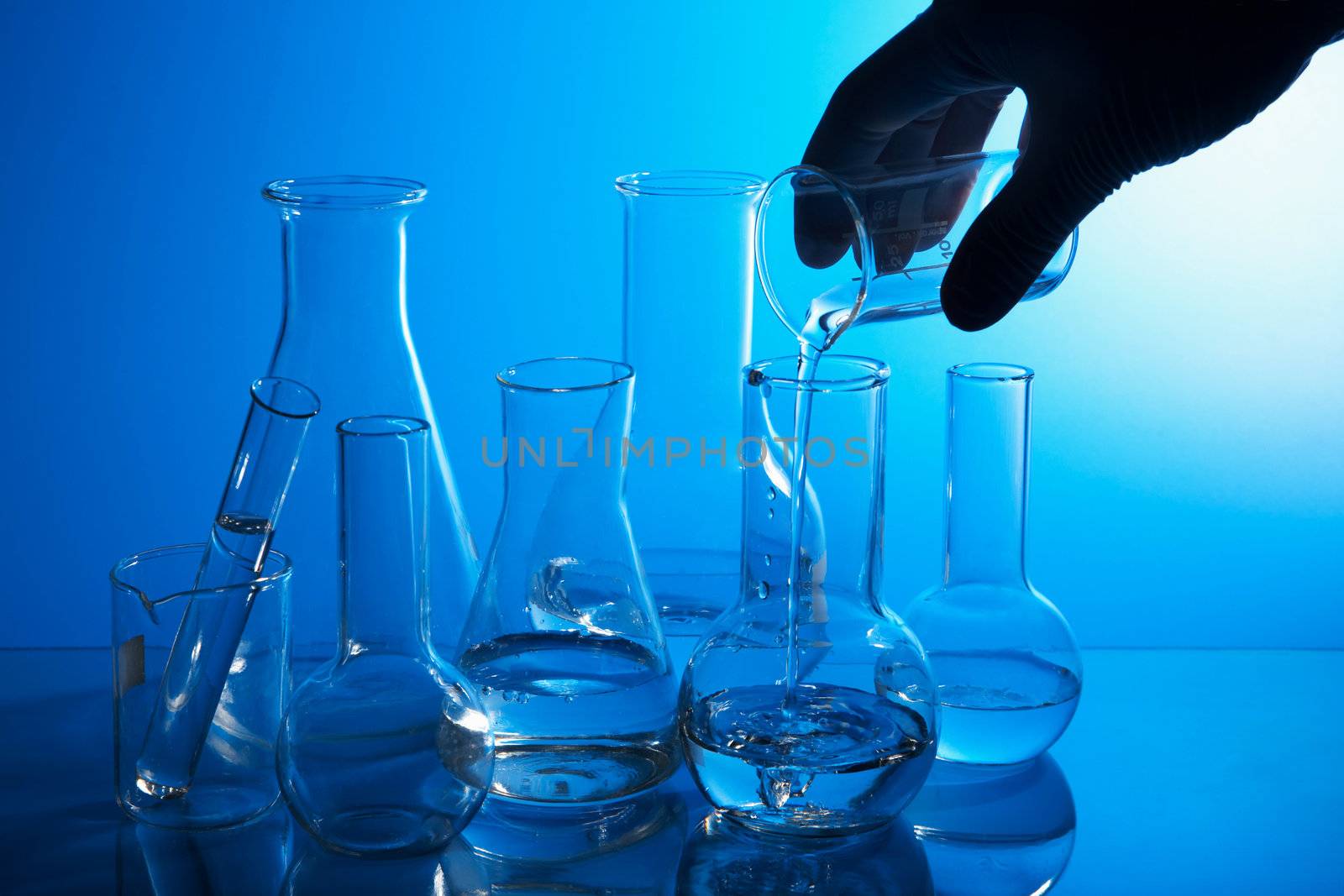 hand pouring liquid into flask 