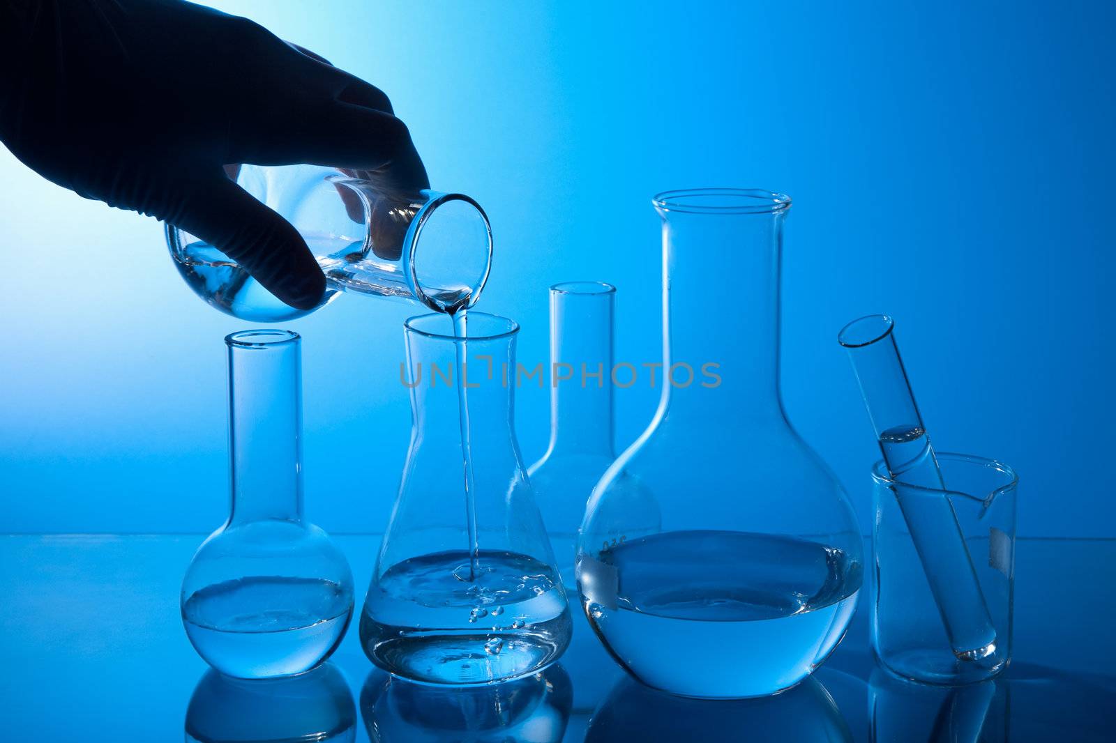 hand pouring liquid into flask