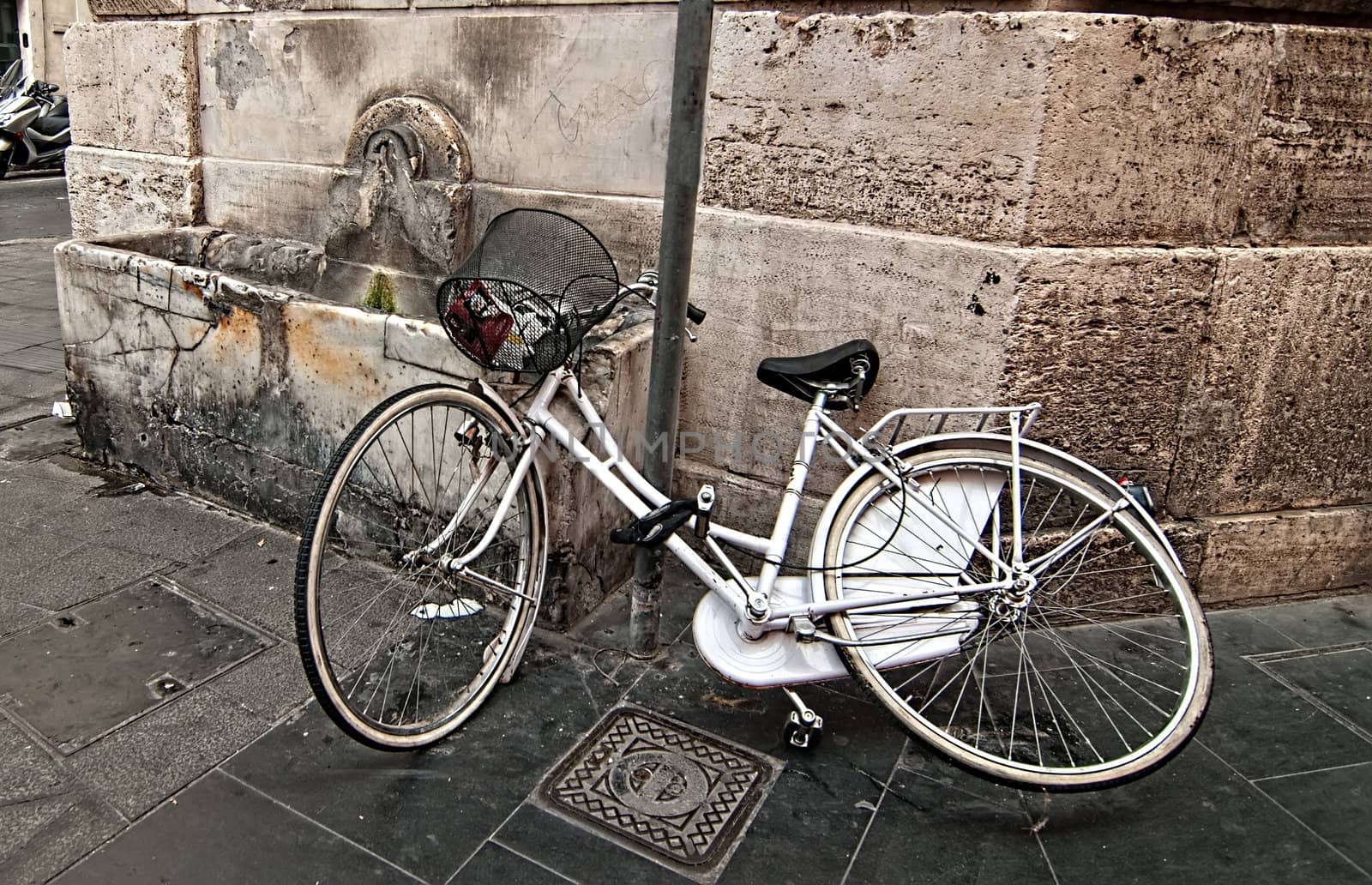 A lone bicycle thrown on the street. Rome. Italy.