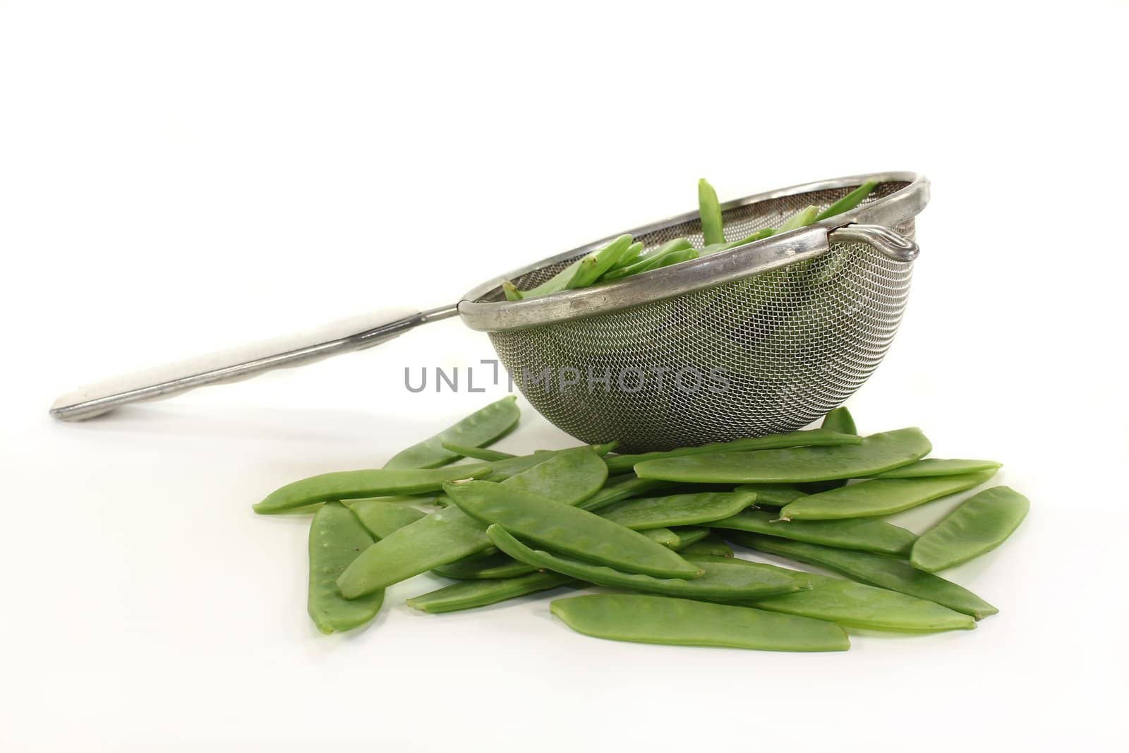 green sugar peas in a sieve