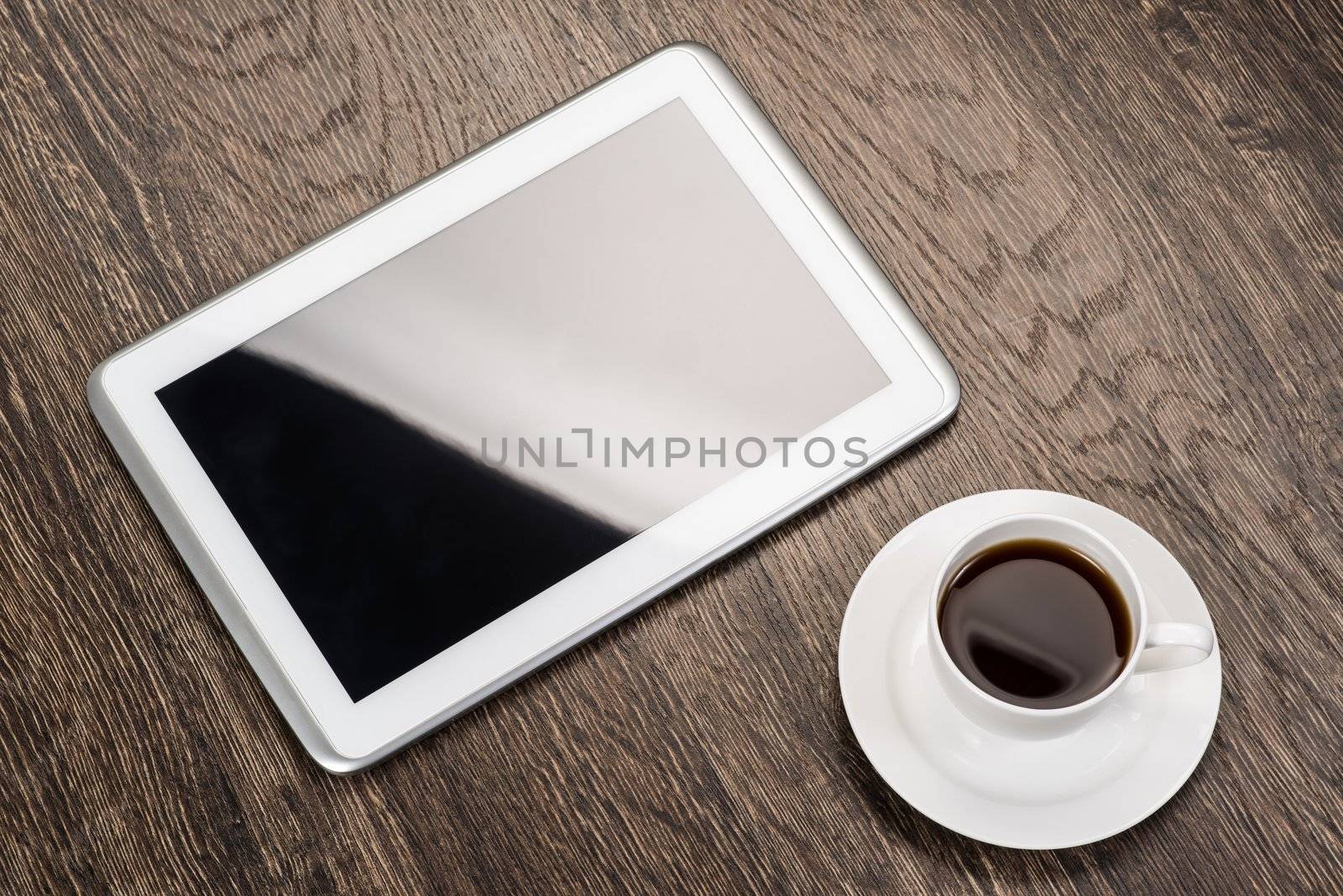 tablet and cup of coffee are on the table, still life