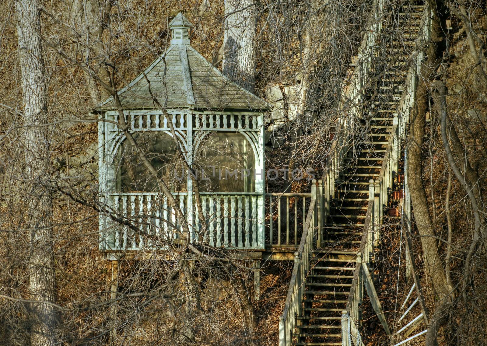 Spring view of gazebo on slope with wooden staircase