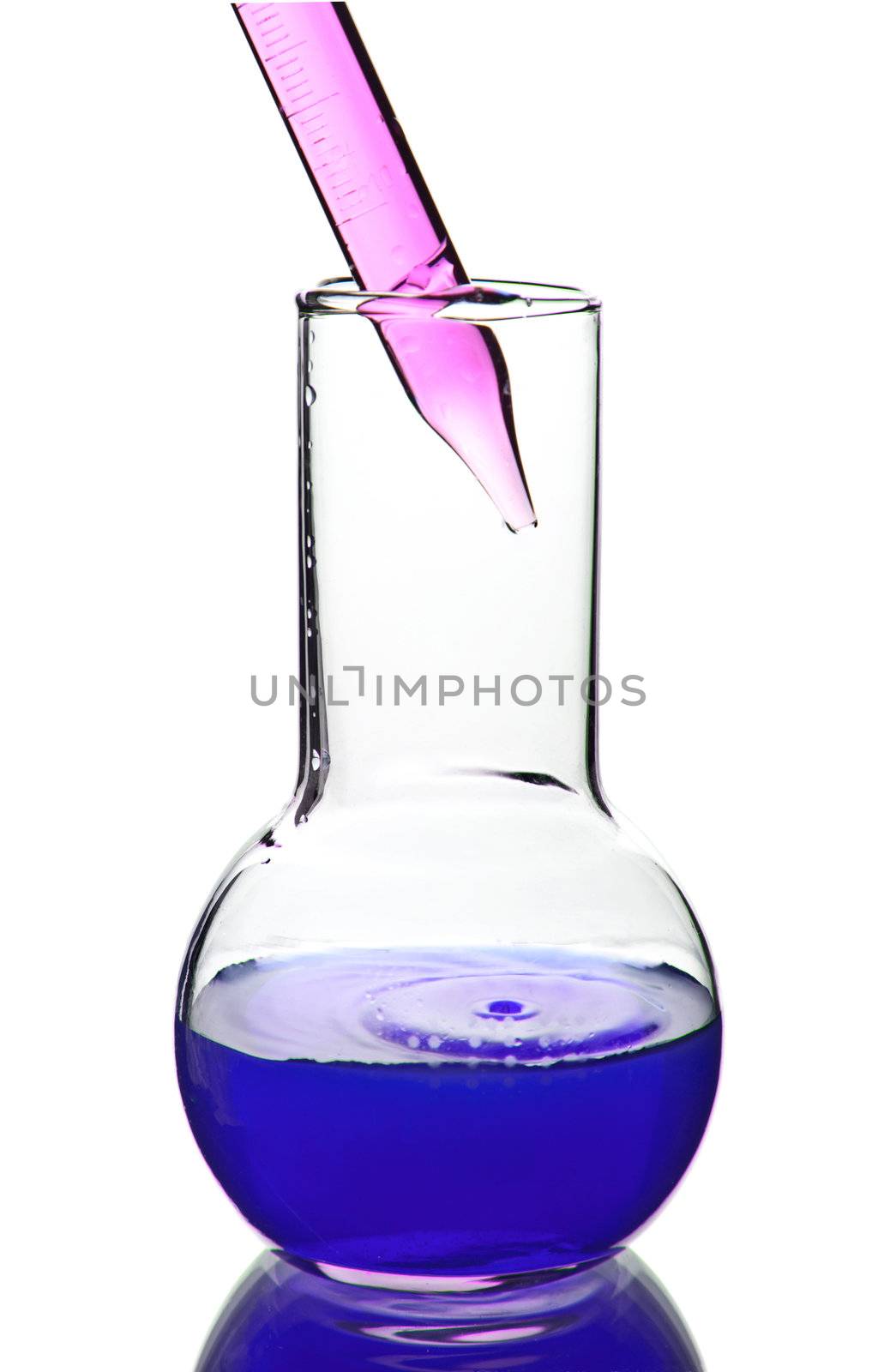 liquid dripping from pipette into flask isolated