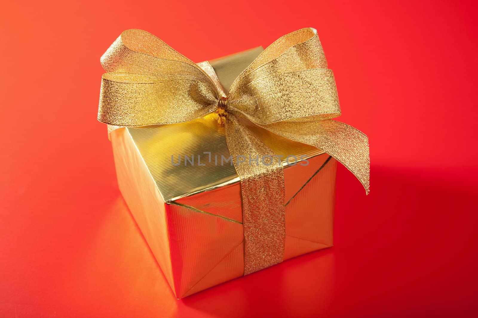 golden gift box over red background 