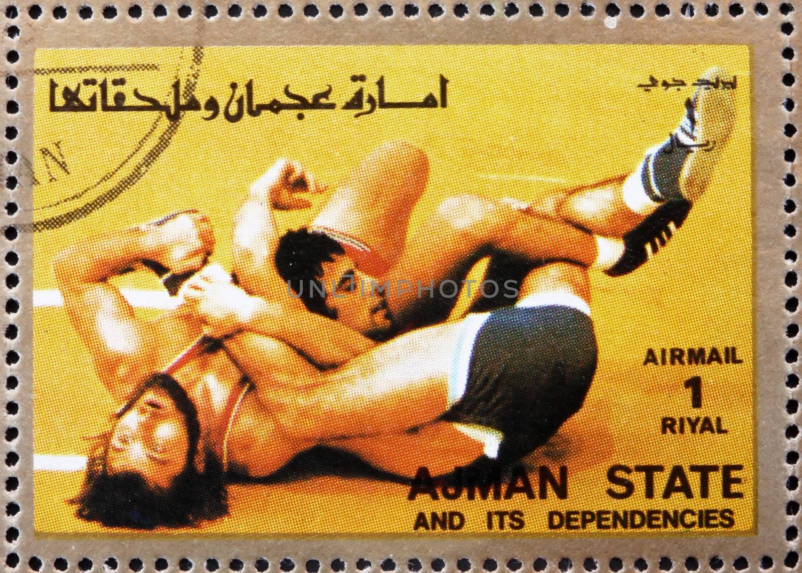AJMAN - CIRCA 1973: a stamp printed in the Ajman shows Wrestling, Olympic sports, circa 1973