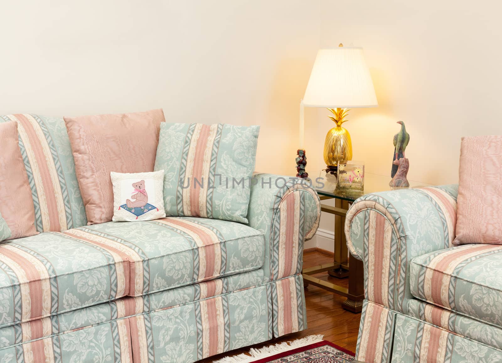 Modern living room with green and pink settees, glass table