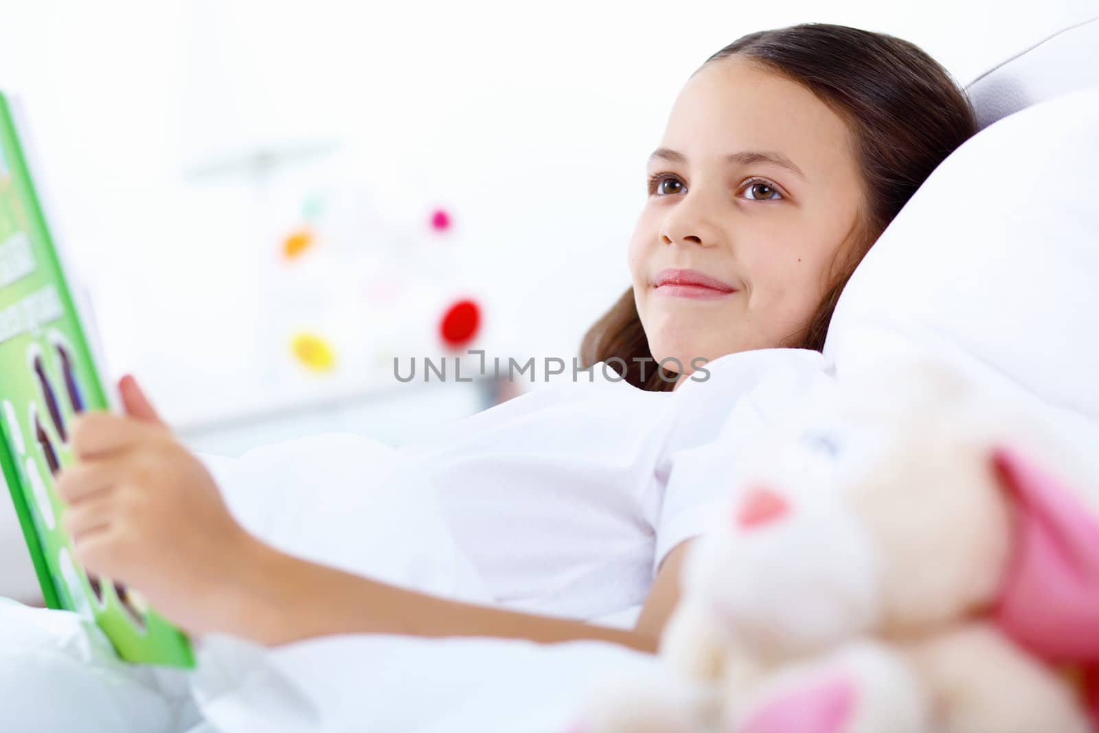 Portrait of girl with a book in bed at home