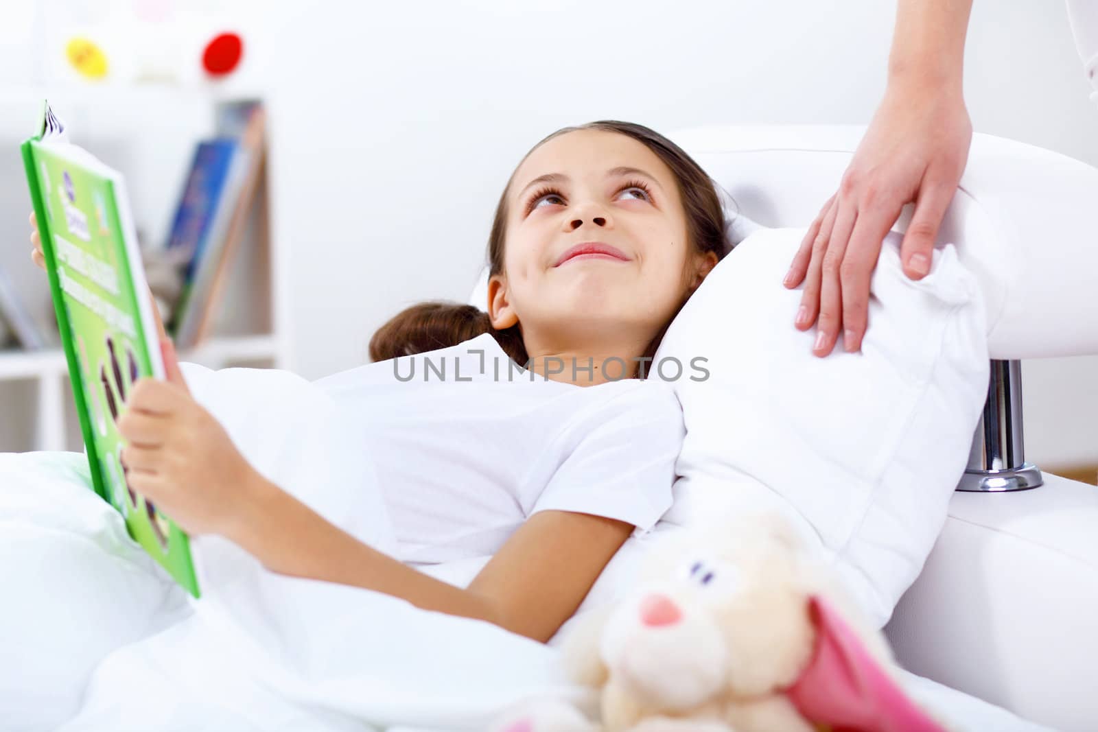 Portrait of girl with a book in bed at home