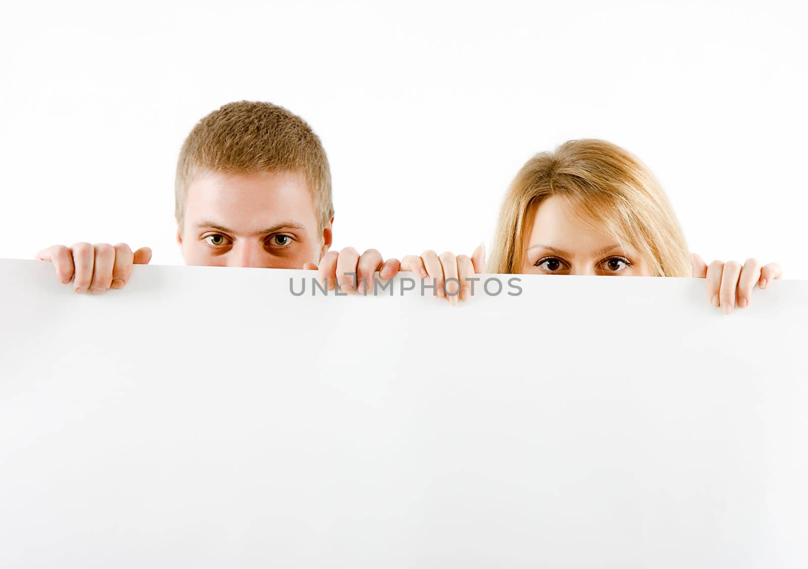boy and a girl peeking from a white sheet of paper