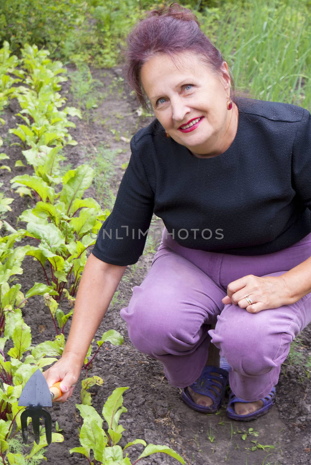The happy smiling woman works on a garden site